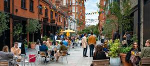 a group of people sitting at tables in a street at The Seraphina Suite - Chelsea in London