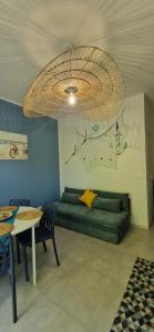 a living room with a green couch and a chandelier at Alis home 100 mt dal mare in Loano +20 photos