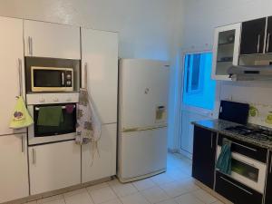 a kitchen with a refrigerator and a microwave at Maison El Omrane 2 in Bin Rhilouf