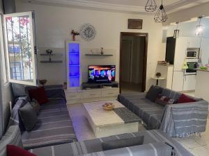 a living room with a couch and a tv at Maison El Omrane 2 in Milletville