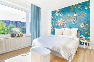 a bedroom with a large bed with a blue wall at City Cocoon in Ratingen