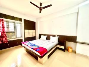 Un dormitorio con una cama y un ventilador de techo. en Vista Royale Greens 104 2bhk, en Patna