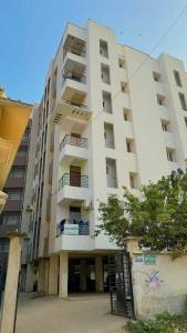 un edificio blanco alto con una puerta delante en Vista Royale Greens 104 2bhk, en Patna