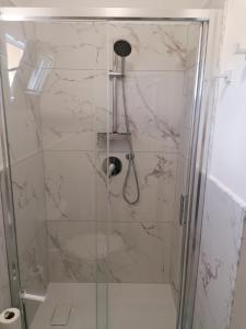 a shower with a glass door in a bathroom at Villa Porto fossa 2 in Marzamemi +6 photos