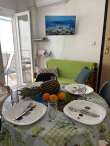 a table with plates and fruit on top of it at Polichrono Seaside Apartment in Polykhrono