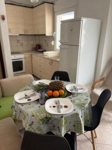 a kitchen with a table with fruit on it at Polichrono Seaside Apartment in Polykhrono