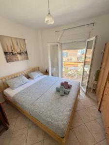 a bedroom with a bed with a teddy bear on it at Polichrono Seaside Apartment in Polykhrono