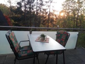 a table and two chairs on a balcony with the sunset at Waldhaus Agnes in Sulzfeld