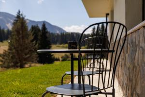two chairs and a table with a coffee cup on it at Mountain View Chalet - Poiana Brasov in Braşov