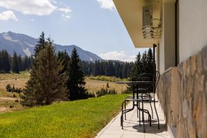 a table and chairs on a porch with a view at Mountain View Chalet - Poiana Brasov in Braşov