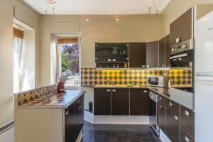 a kitchen with brown cabinets and a counter top at Colmar Apartment in Colmar