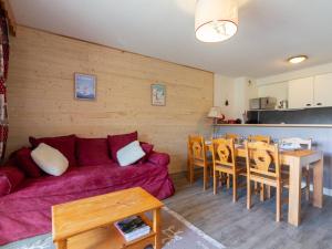 a living room with a red couch and a table at Appartement 8 pers Peyragudes, Wifi, Parking, Navette proche - FR-1-695-66 in Gouaux-de-Larboust