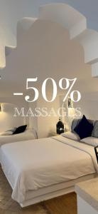 a bedroom with two beds with a sign on the wall at Hotel Al Alba Hammam & Restaurant in Asilah