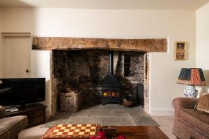 ein Wohnzimmer mit Kamin und Fernseher in der Unterkunft Rose Cottage - sleeps 6 in Dorchester
