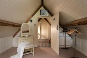 ein Dachzimmer mit Spiegel und Treppe in der Unterkunft Rose Cottage - sleeps 6 in Dorchester
