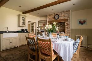a kitchen with a table with a vase of flowers on it at Tincleton Lodge & Rose Cottage - sleep 16 in Dorchester