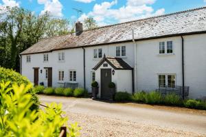 a white house with a gambrel roof at Tincleton Lodge & Rose Cottage - sleep 16 in Dorchester
