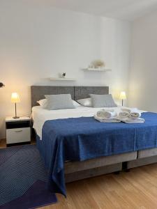 a bedroom with a large bed with a blue blanket at Seaview apartment Bava in Zaton