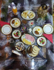 Una mesa cubierta con platos de comida sobre una mesa. en Guest House Sadbarg, en Samarkand