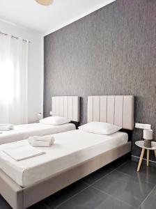 a bedroom with two beds and a wall at Margarita in Chania +8 photos