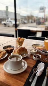 a table with a cup of coffee and food on it at HOTEL COLL OFICIAL - BRAGADO Provincia de Bs As in Bragado +8 photos