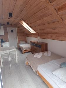 a bedroom with two beds and a table in a room at Krutyńska Sielanka in Piecki