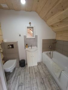 a bathroom with a toilet and a tub and a sink at Krutyńska Sielanka in Piecki