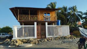 a house with a balcony on the beach at Cabaña los recuerdos de ella in Moñitos