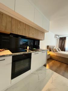 a kitchen with white cabinets and a black stove top oven at DeLuxury Apartment Chmielna in Warsaw