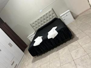 Una cama negra con dos zapatos blancos encima en Depto XL Villa Unión, en Villa Unión