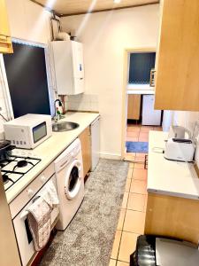 a kitchen with a washing machine and a sink at Premium Cozzy Corner in Leicester