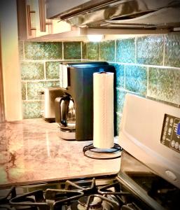 - un comptoir de cuisine avec une cafetière et des serviettes en papier dans l'établissement Urban Coach Casa - Medical District- 10 to Downtown, à Chicago 6 autres photos