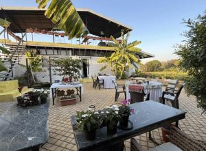 a patio with two tables and chairs with flowers on it at SaffronStays Onellaa, Nashik - infinity pool villa surrounded by a vineyard in Nashik
