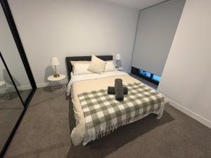 a bedroom with a bed with a black and white blanket at Brand new 1B apartment in Woden near Hospital Westfield and pool gym in Phillip +12 photos