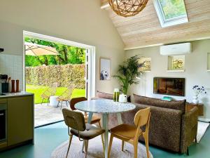 a living room with a table and chairs and a couch at Wilde Gist Guesthouse in Sint Agatha