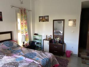 a bedroom with a bed and a mirror at Amwaj ground apartment in El Alamein