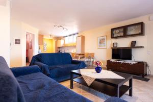 a living room with two blue couches and a table at Artemis Riviera Near Athen's Airport in Artemida