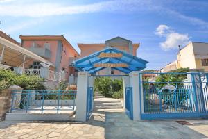 a blue gate with street signs in front of a building at Dolphin Hotel in Skopelos Town