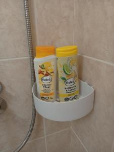a shelf with three bottles of cleaning products in a bathroom at Apartman Slađa in Novi Sad +22 photos