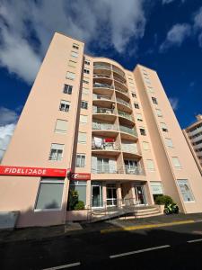 a large apartment building with a red sign on it at Green Seaty View in Ponta Delgada
