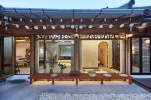 Una casa con una gran pared de cristal con patio. en Suncheon 20 days hanok private stay, en Suncheon