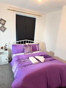a purple bed with two pillows on top of it at Premium Cozzy Corner in Leicester