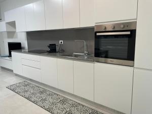 a white kitchen with a sink and a microwave at Marina Garden in Cattolica