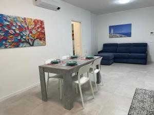 a living room with a table and a blue couch at Marina Garden in Cattolica +17 photos