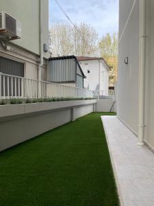 a balcony with green grass on the side of a building at Marina Garden in Cattolica