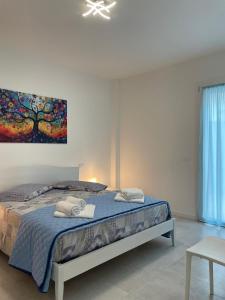 a bedroom with a bed with a painting on the wall at Marina Garden in Cattolica