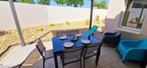un tavolo e sedie blu su un patio di "LE BONHEUR EST DANS LE VEILLON" Maison neuve 3 chambres de 2025, 7 personnes, avec jacuzzi 6 personnes et climatisation réversible a Talmont Altre 51 foto