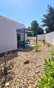 un patio di una casa con tetto di "LE BONHEUR EST DANS LE VEILLON" Maison neuve 3 chambres de 2025, 7 personnes, avec jacuzzi 6 personnes et climatisation réversible a Talmont