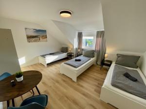 a living room with two beds and a table at Moderne Monteur- und Familienwohnung auf Zeit in Remscheid Süd in Remscheid