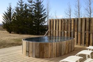 a wooden deck with a pool of water next to a fence at Borealis Hotel in Selfoss
